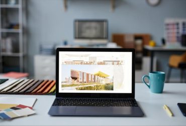 Close-up of photo of new project on the screen of laptop standing on workplace of designer in office